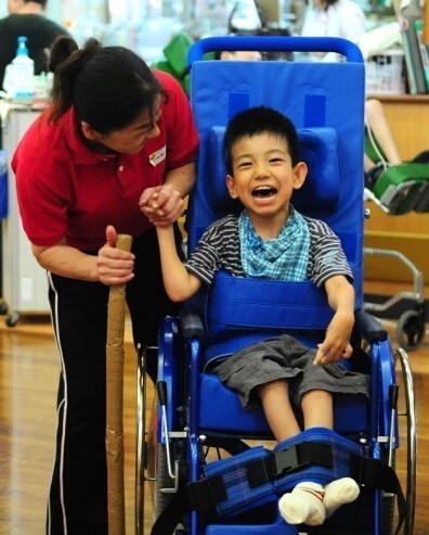 cyshcn-1 young boy in wheelchair holding hands with an adult